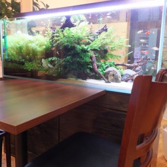 1200サイズの熱帯魚が泳ぐ水槽の横のテーブルは、癒しの空間として人気です。