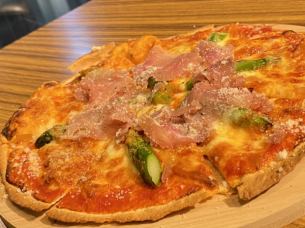Pizza with prosciutto and asparagus in tomato sauce