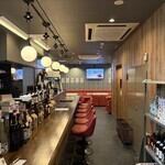 テーブル席は会話しやすい距離感を重視し、落ち着いて過ごせる配置に。赤いソファの座り心地も良く、長時間の利用でも快適です。用途を選ばず使える万能なお席となっています。木目調のカウンター席は、ひとり飲みや少人数利用にもおすすめです。目の前に並ぶボトルを眺めながらゆったりとした席間で、会話も自然と弾みます