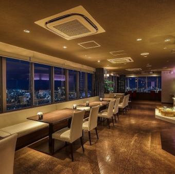 大きな窓から那覇近郊の夜景を一望できるテーブル席です。全86席の広々とした店内は、15名様からの少人数利用も可能。ガラス張りの開放的な空間で、ホテル最上階ならではの贅沢な眺望を楽しみながらお食事ができます。お集まりの人数に合わせ、最適なお席をご案内いたしますので、お気軽にご相談ください。