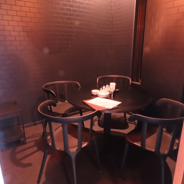 開放的な店内のテーブル席がある一方で、個室はプライベート感を重視しています。テーブル上の赤い光が特別な雰囲気を作り出します。