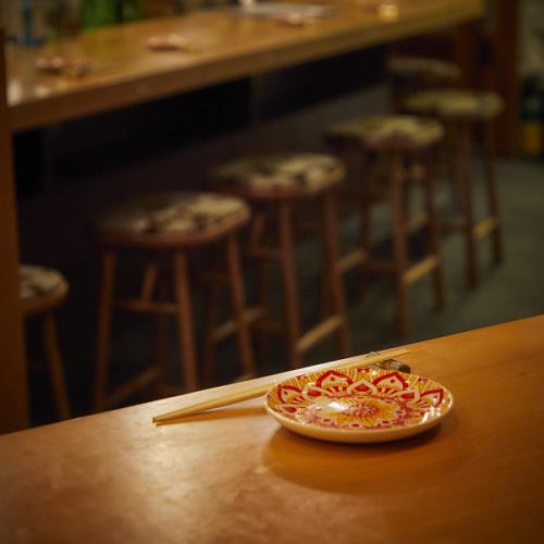 一歩足を踏み入れた瞬間、静けさと香ばしい香りに包まれる。全席カウンターの店内では、料理人が目の前で藁焼きの調理を披露。立ちのぼる煙、火の音、香ばしい香り──五感を通して料理と向き合える“体験の場”です。