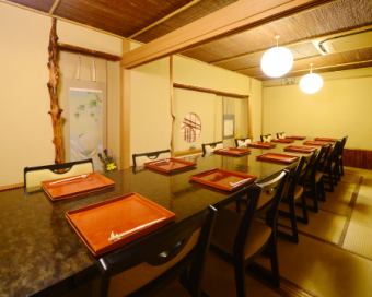 Up to 20 people are seated at tables and chairs in a tatami room.