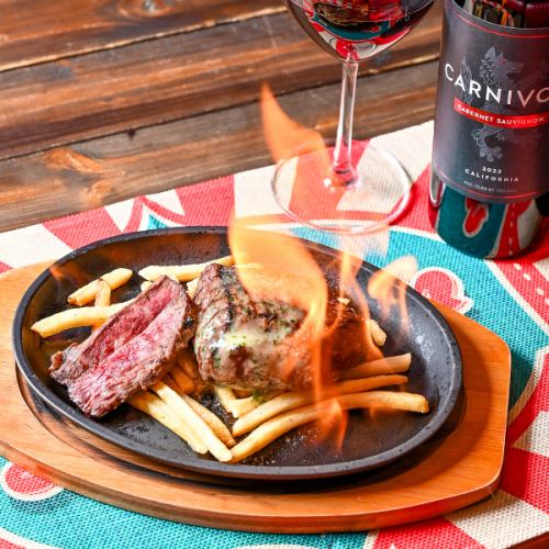 目前で上がる炎に歓喜。ランプ肉の旨味を閉じ込めた豪快ステーキ。