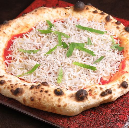 Tomato-based pizza with whitebait and shiso leaves