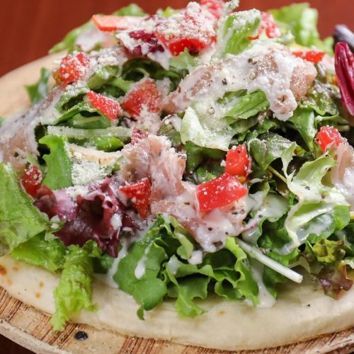 Pizza with prosciutto and Caesar salad