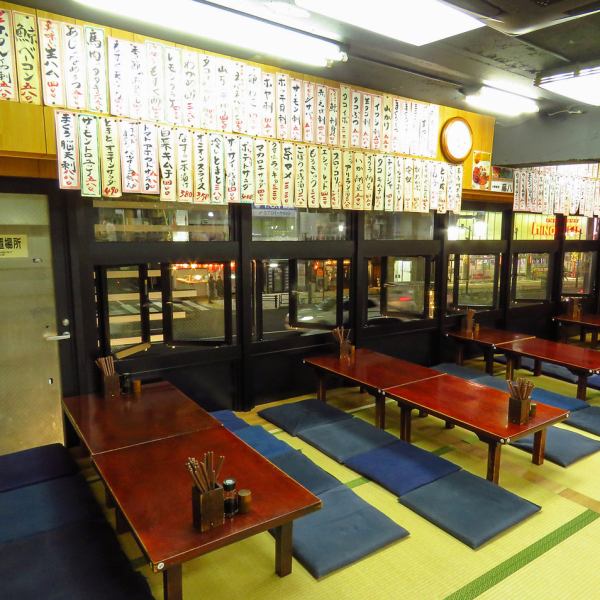 【広々とした店内】靴を脱いで畳の上で、ゆっくりお寛ぎいただけます。暖かみのある空間の中で、懐かしさと贅沢な時間を感じながらゆっくりお酒、料理をお楽しみください。壁一面に貼られたメニューを見渡しながらご注文下さい。