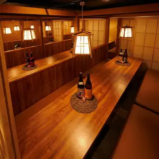 A high-quality banquet space filled with warm-toned light, where the beauty of wood shines through in every corner of the store.The rows of seats arranged on a single plank of wood, prominently placed in the center, allow you to see all the guests' faces, making it ideal for celebrations and gatherings surrounding the guest of honor at company banquets.The comforting warmth you feel no matter where you sit, combined with the sophisticated Japanese modern design, further enhances the elegance of the entire gathering.