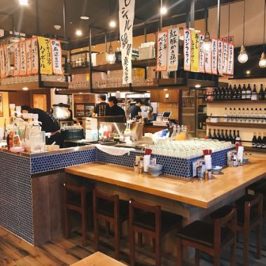 【店内中央に位置するメインの大カウンター席１】当店の自慢は店内中央に位置する２つの大カウンター！！こちらは入口目の前にあるメインカウンターです。たくさんのメニュー短冊が並び、活気のあるスタッフがドリンクを作りながらお店の雰囲気を盛り上げる中心部。１名様でのご利用も多く、人気のお席となっております。