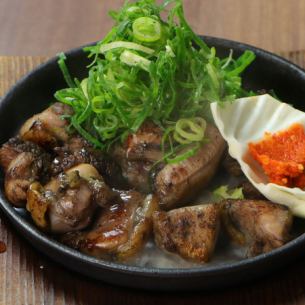 鐵板上烤雞腿，撒上蔥花