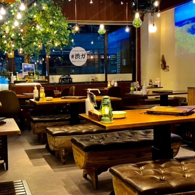 Inside the Shibuya Garden Space Dogenzaka store, wooden tables with images projected onto two walls.
