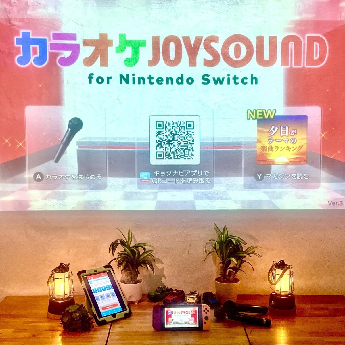 전세로 무료 노래방 JOYSOUND(Nintendo Switch)를 대형 스크린 프로젝터에 투영해, 마이크와 태블릿을 늘어놓은 모습