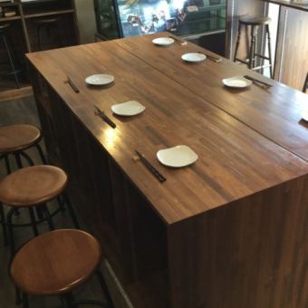 お店の中央に、柔らかい印象の木製テーブルがございます。3名～8名のお客様でご使用いただけます。