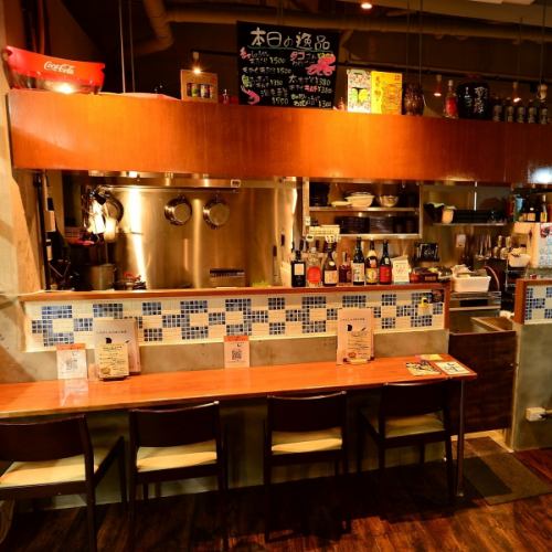 <p>温かみのある木のカウンターとタイルのアクセントが心地よい空間。料理の香りや音を間近で感じながら、ゆったりとした時間をお過ごしください。</p>