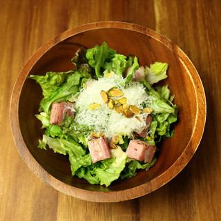 Caesar salad with thick-sliced bacon and pistachio