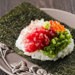 1 piece of tuna hand-rolled sushi topped with condiments