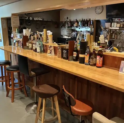 【多彩なお酒が並ぶカウンター】店内の棚には、自慢の焼酎やプレミアムなウイスキーなどのお酒がズラリと並びます。お酒のボトルを眺めながら、次の一杯を選ぶのも楽しいひととき。お一人様はもちろん、気の置けないご友人や同僚と肩を並べて語り合うのにも最適です。美味しいお酒で一日の疲れをリフレッシュ★