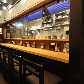 一楼设有六个吧台座位，非常适合独自用餐的客人。这些座位非常适合下班后快速喝一杯，独自喝一杯，甚至可以和坐在旁边的人聊天。您可以尽情欣赏工匠们的精湛技艺和品尝美味的酒水。我们提供舒适温馨的氛围，期待您的光临。