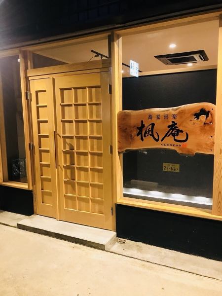 木の温もりが漂うモダンな外観。大きな一枚板の看板に「楓庵」の名が刻まれた、趣ある蕎麦処の店構えです。