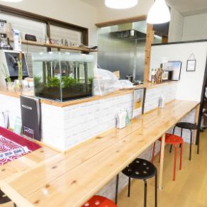 这是一个令人放松的空间，即使一个人也可以随意使用。餐厅内摆放着宽敞的木质餐桌，散发着温暖的气息，餐桌前还设置了水族箱，营造出轻松的氛围。这是一个特别的座位，非常适合在午餐或咖啡时间放松身心。