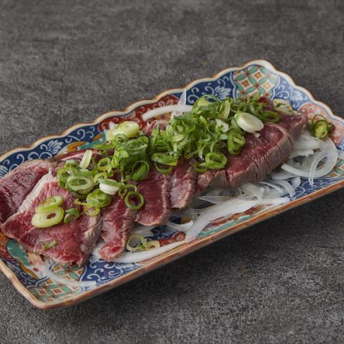 Grilled beef covered in green onions