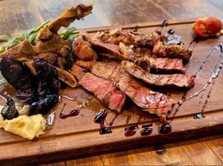 Bone-in T-bone steak with grilled vegetables and balsamic sauce