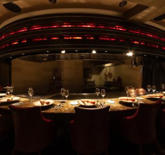 A private space with only eight seats at the chef's table with a large iron plate.