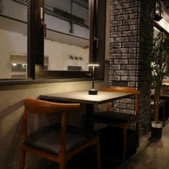 窓辺に配されたテーブル席は、柔らかな照明が心地よい空間を演出します。親しい方との語らいや、大切な方とのデートに最適な、心安らぐプライベート空間です。落ち着いた雰囲気の中、ゆっくりと美食の夜をお過ごしいただけます！