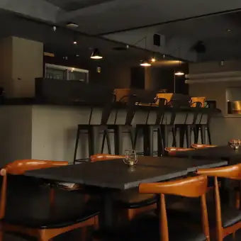 控えめな照明が落ち着きを演出するテーブル席は、穏やかな時間を過ごしたい夜にぴったりです。自慢の料理を心ゆくまでお召し上がりいただける、特別な夜のひとときをお過ごしください。