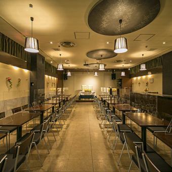 ステージが大きく余興に便利!縦長のテーブルレイアウトで、奥の席からでもステージが見えやすくなっています。スクリーン、照明、音響設備は無料で使い放題。高い天井にブラウンのライトがシックに映える空間です。