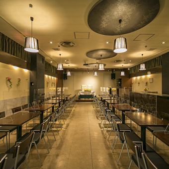 ステージが大きく余興に便利!縦長のテーブルレイアウトで、奥からでも視界良好★ ステージが見えやすくなっています。スクリーン、照明、音響設備は無料で使い放題。照明の操作はスタッフにお任せいただくことも可能です。高い天井にブラウンの照明がシックに映える空間。大人ぽく上質なひと時をお過ごしいただけます。