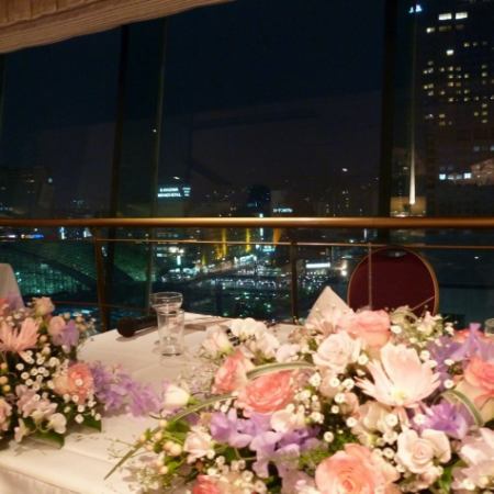 【ブライダル画像】新郎新婦様のお席です。卓上装花はお持込対応できます。夜景をバックに記念写真もＧｏｏｄ！