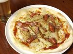 Spicy pizza with sausages and tomatoes
