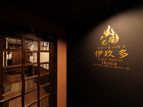 【木の温もりとBGMが響く大人の隠れ家】濃い木目調で統一された店内を、柔らかなライトが照らし、洗練された落ち着いた雰囲気を演出します。心地よいBGMで、時間を忘れてゆったりと流れる特別なひとときをお愉しみください。