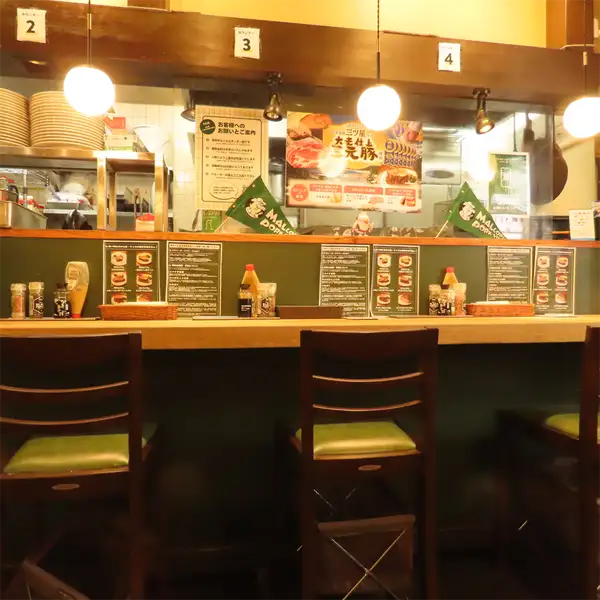 【お一人様も大歓迎】店内には、サクッとお食事を楽しめるカウンター席も完備しております。お仕事帰りの気軽な晩酌や、ご自身のペースでゆっくりとお肉を味わいたい時にも最適です。当店自慢のポークステーキは、グラム数をお選びいただけますので、その日の気分やお腹の空き具合に合わせてご注文ください!