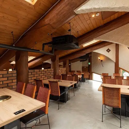 [2nd floor table seating / 30 seats total] Lodge-like ceiling.Perfect for all kinds of parties! The second floor, with its wood-grain interior and brick accents, features a stylish sloping ceiling that evokes the atmosphere of a lodge.We have tables for 4 or 6 people, so we can accommodate various group sizes, from small to large.