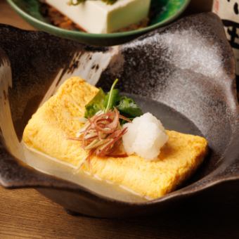 Rolled egg with plenty of dashi stock - garnished with mitsuba and myoga ginger -