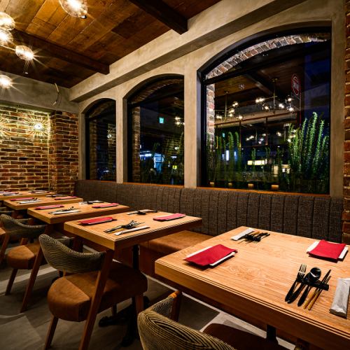 一樓的桌椅營造了一種輕鬆、樸實的氛圍。這家餐廳的魅力在於，你可以一邊享用柴火烤披薩和義大利麵，一邊度過一段熱鬧愉快的時光。這裡是與朋友小酌一杯或小型聚會的理想場所。