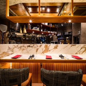 一樓的吧台座位是特別的座位，您可以肩並肩地坐著，享受開放式廚房帶來的沉浸式氛圍。觀看廚師烹飪，沉浸在香氣和聲音中，會讓你們的約會更加特別。