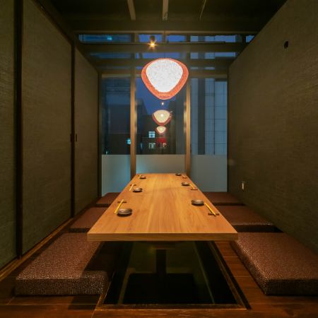 A private room with a sunken kotatsu table and a glass wall / the ceiling is open