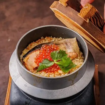 Freshly cooked rice in a pot with salmon roe and salmon