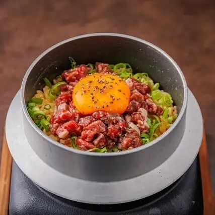 Freshly cooked rice in a pot with aged meat and garlic
