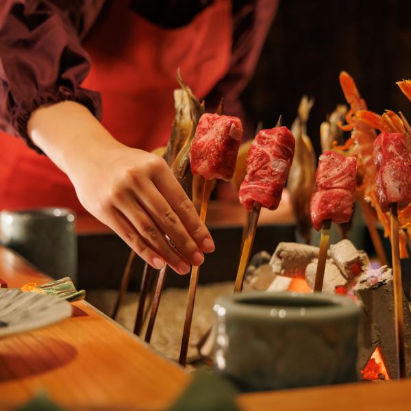 【非日常の雰囲気とおもてなし】普段では味わえない囲炉裏を囲んだ席が魅力的な個室を準備しております。囲炉裏を囲んで焼き上げる料理はスタッフが焼き加減を見ながら必要最低限の対応で見極めます。個室の中への出入りは出来る限り控えてお客様のお時間を大切にします。