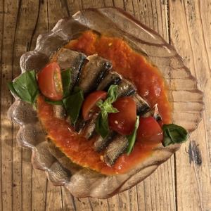 Small plate of marinated sardines, basil and tomatoes