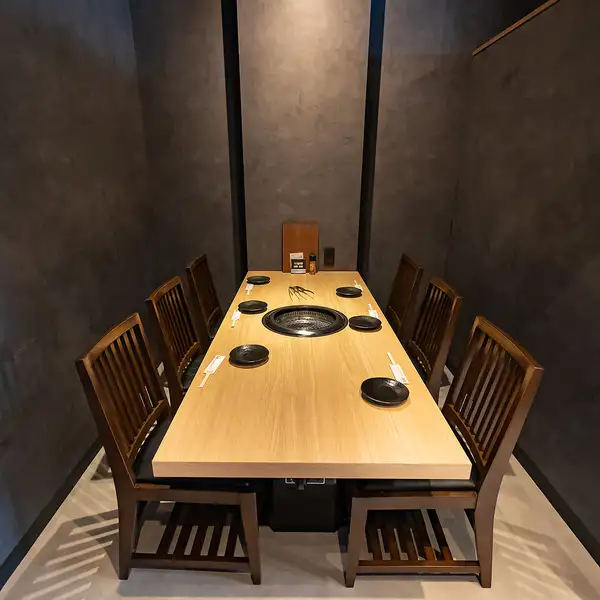 黒を基調としたシックな店内。1階は炭火焼き、2階はロースター、3階は無煙ロースターを完備した個室空間で、シーンに合わせた利用が可能。デートや記念日、ファミリーでの食事にも対応し、おしゃれなカウンター席や貸切スペースまで備え、幅広いニーズに応えます。サプライズ演出も可能。