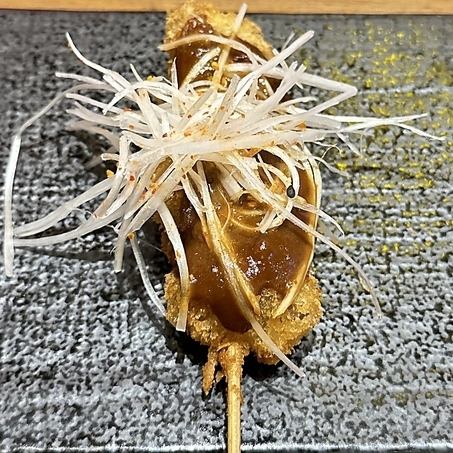 Deep-fried skewers of beef tendon with green onion miso sauce