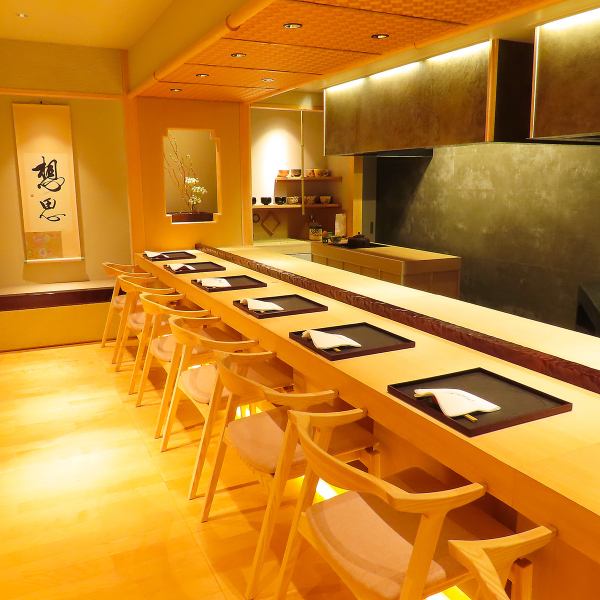 【洗練された大人の空間】黒木調の落ち着いた店内。カウンター席が11席ある洗練された空間。それでいて、どこか遊び心ある雰囲気。居心地よく、緊張感を和らげてくれます。ウェイティングルーム(バー)では、ソムリエが選び抜いた、選りすぐりのワインを楽しみながら、リラックスしたひとときをお過ごしいただけます。
