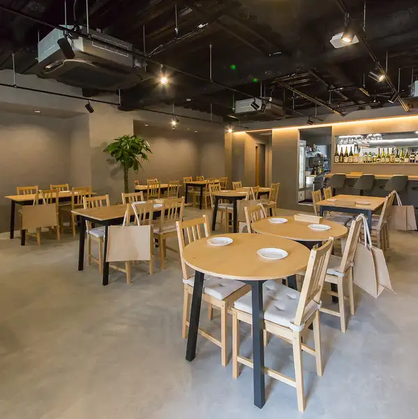 洗練されたモダンな質感と木の温もりが調和するスタイリッシュな店内。開放感あふれる空間は、少人数のお食事からお店を贅沢に使った貸切パーティまで対応可能です。飲み放題付きコースとともに、大切なご宴席や集まりに上質で心地よい一体感を演出いたします。
