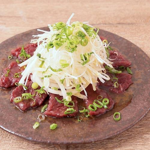 Horse sashimi covered in green onions