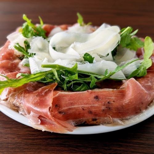 PIZZA with protruding raw ham and arugula